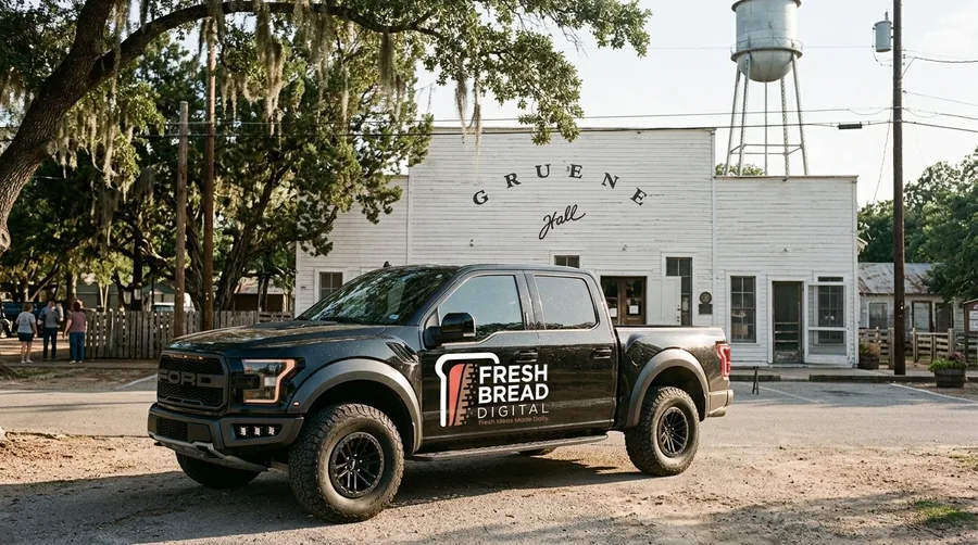 Black pickup truck with the Fresh Bread Digital logo on the door, parked in front of Gruene Hall in New Braunfels, Texas