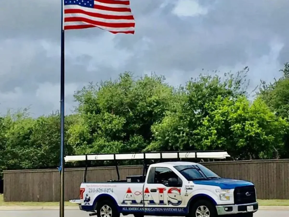 All American Irrigation Systems truck parked under an American flag